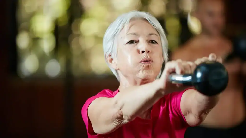 Older woman doing weight training Buckingham to help her strength and longevity 