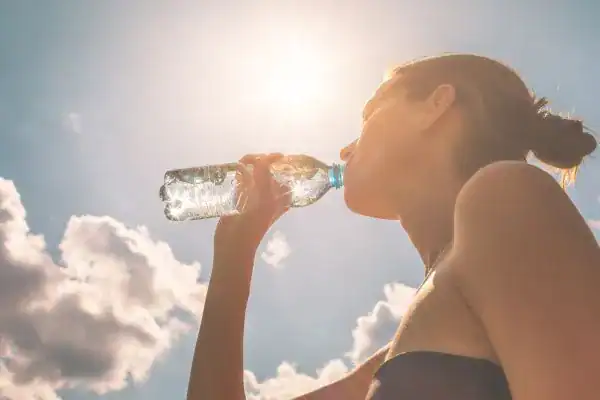 Hydration: The Secret Ingredient for a Toned Stomach and Enhanced Fitness 3 Image of woman drinking water to hydrate Buckingham after run.